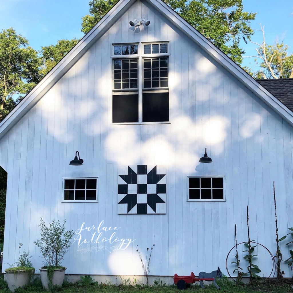 barn quilt hung on side of garage