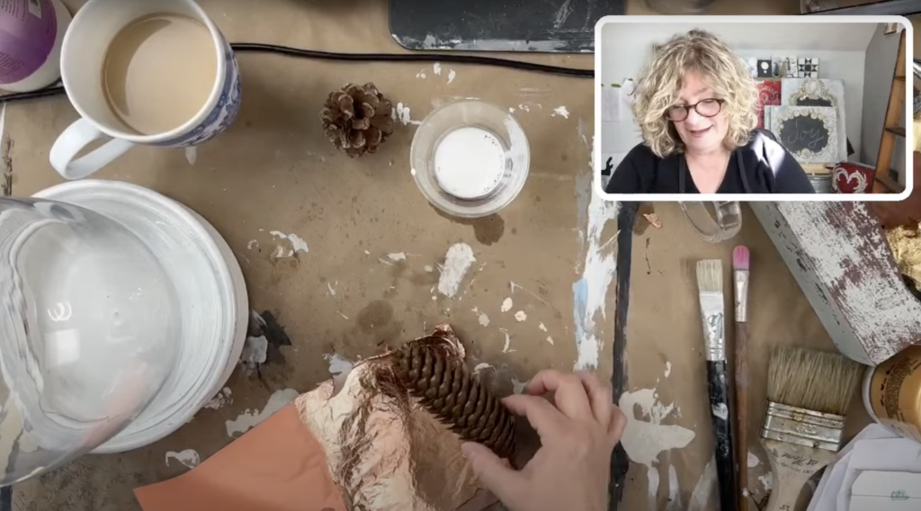 applying copper leaf to pine cones